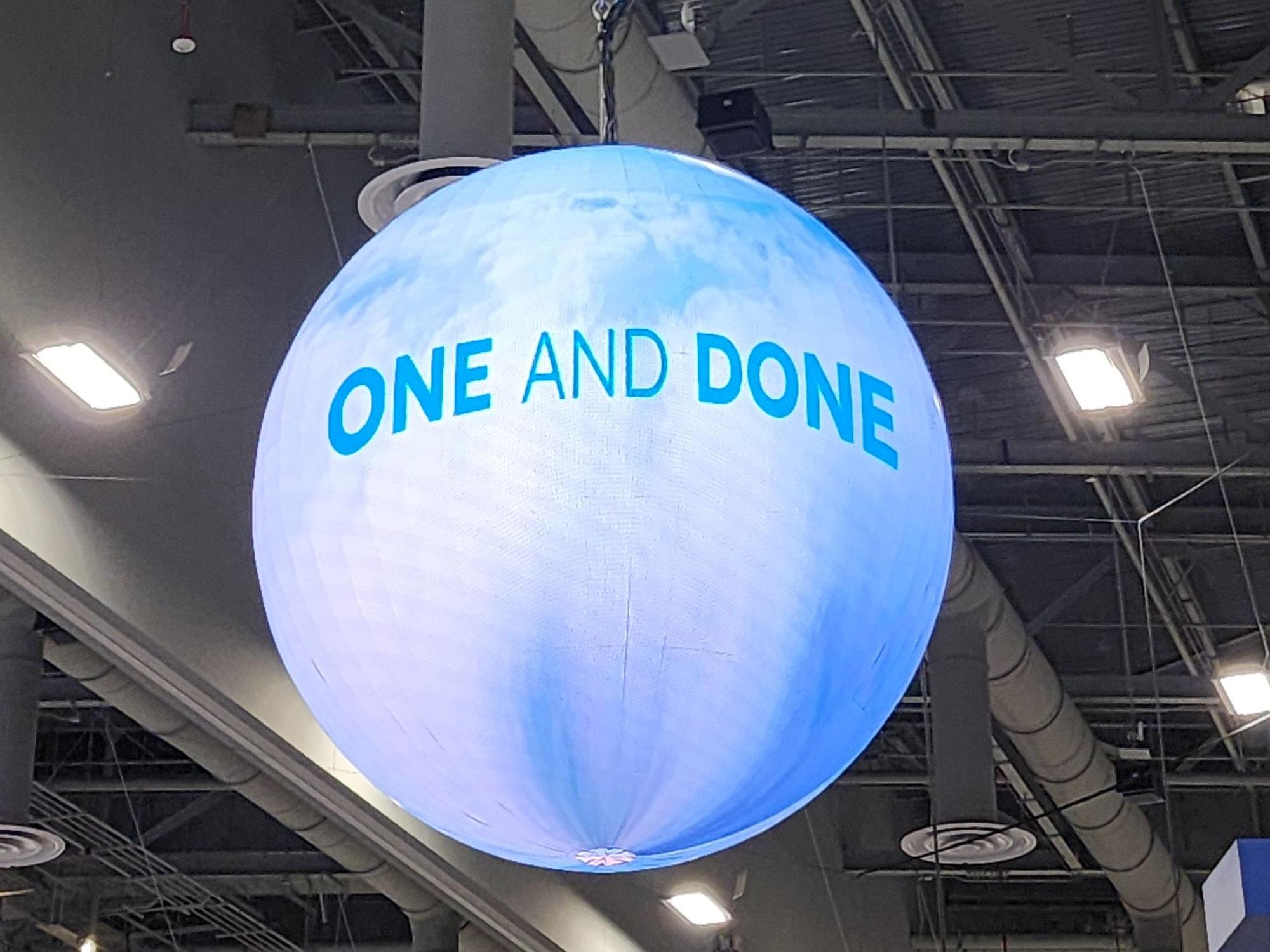 LED sphere rigged overhead inside a hangar-style trade show hall