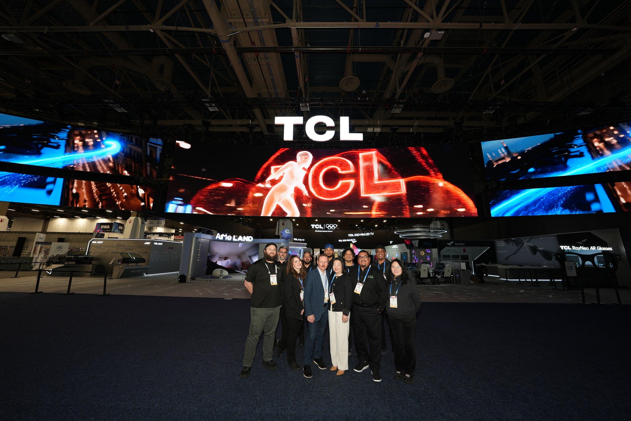 The TLL crew on a trade-show floor in front of a large LED wall