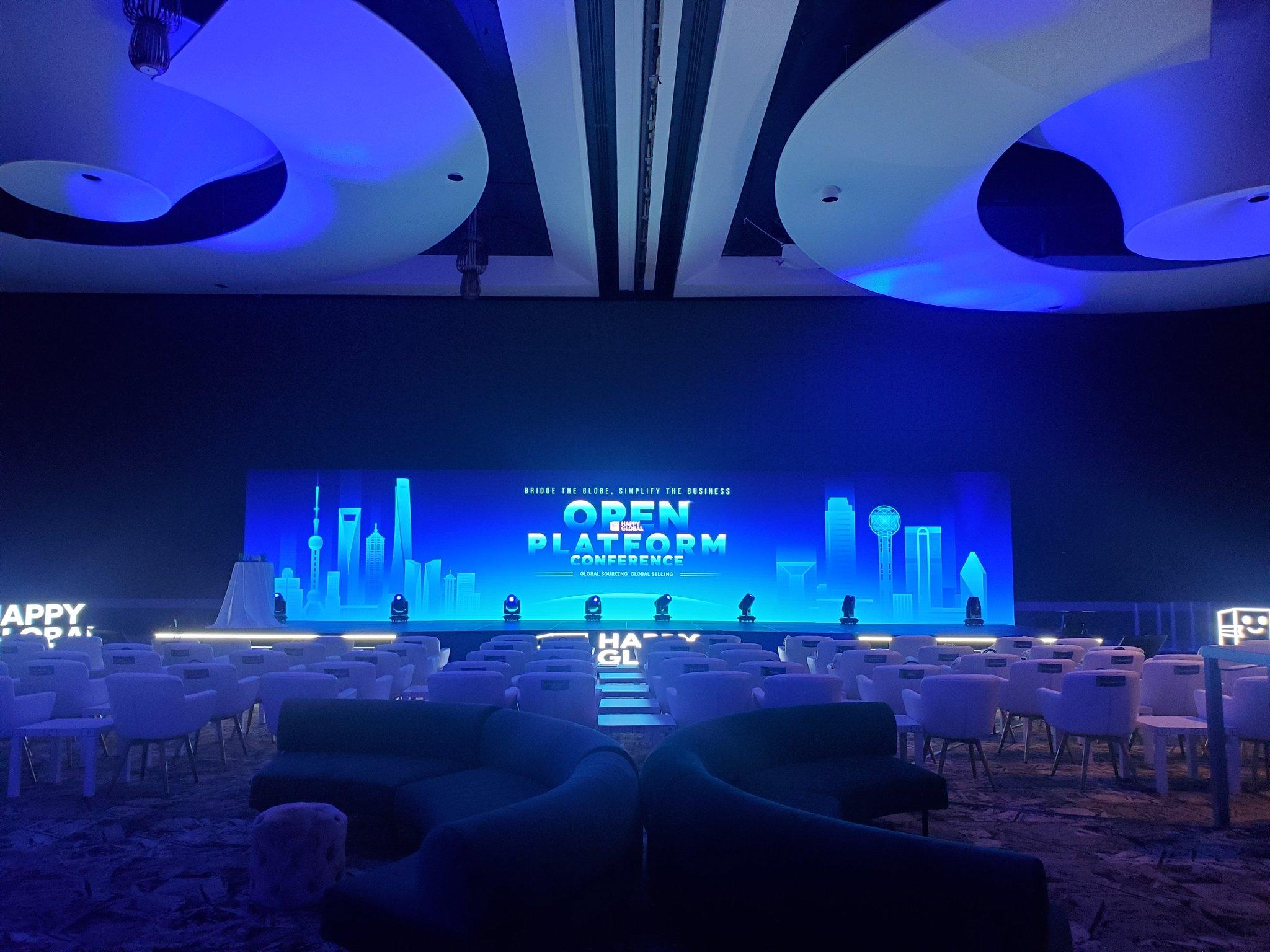Keynote speaker on stage in front of a branded LED wall