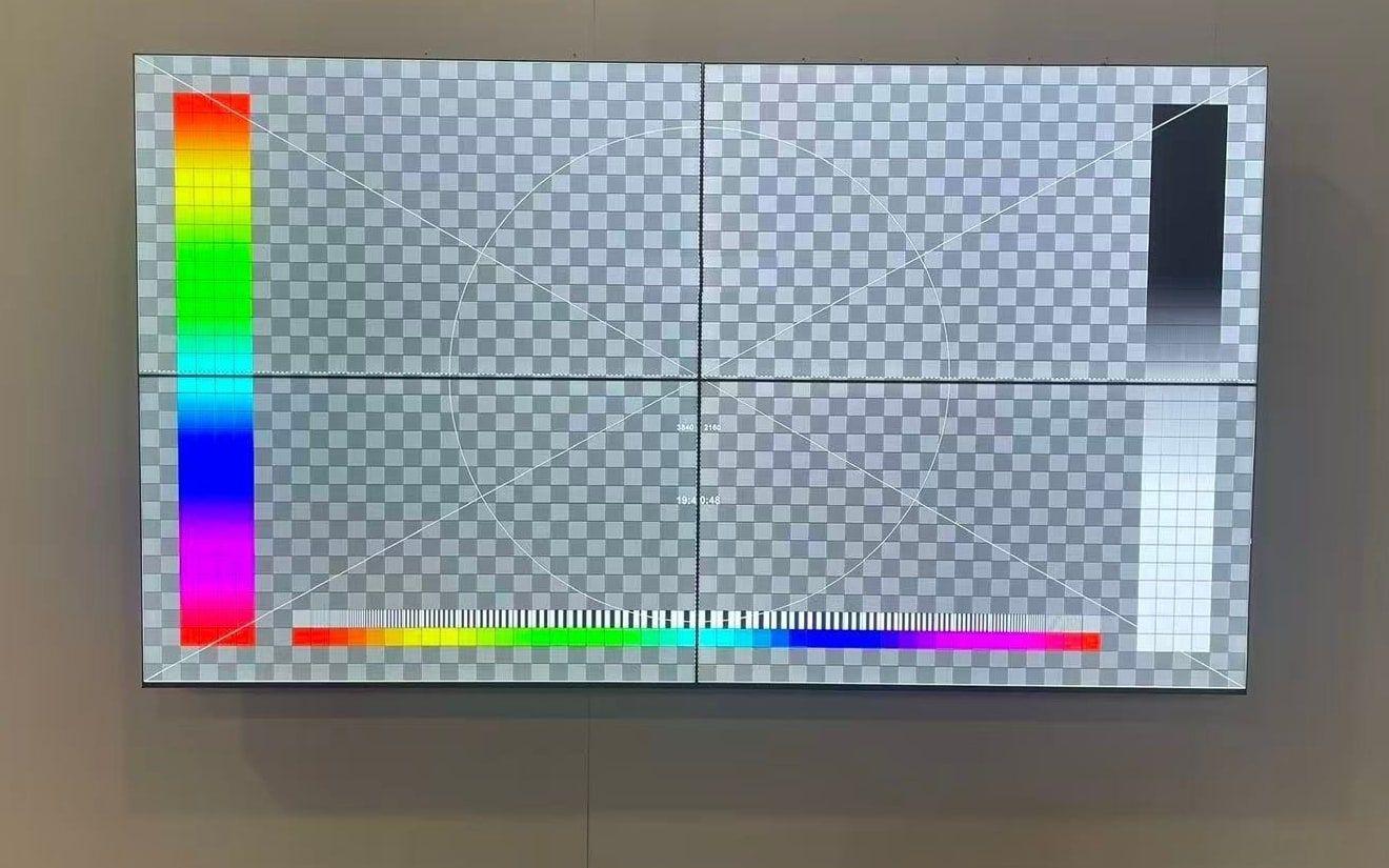 A 2 x 2 wall of ultra-slim bezel LCD panels showing a test pattern, with thin seams between the panels