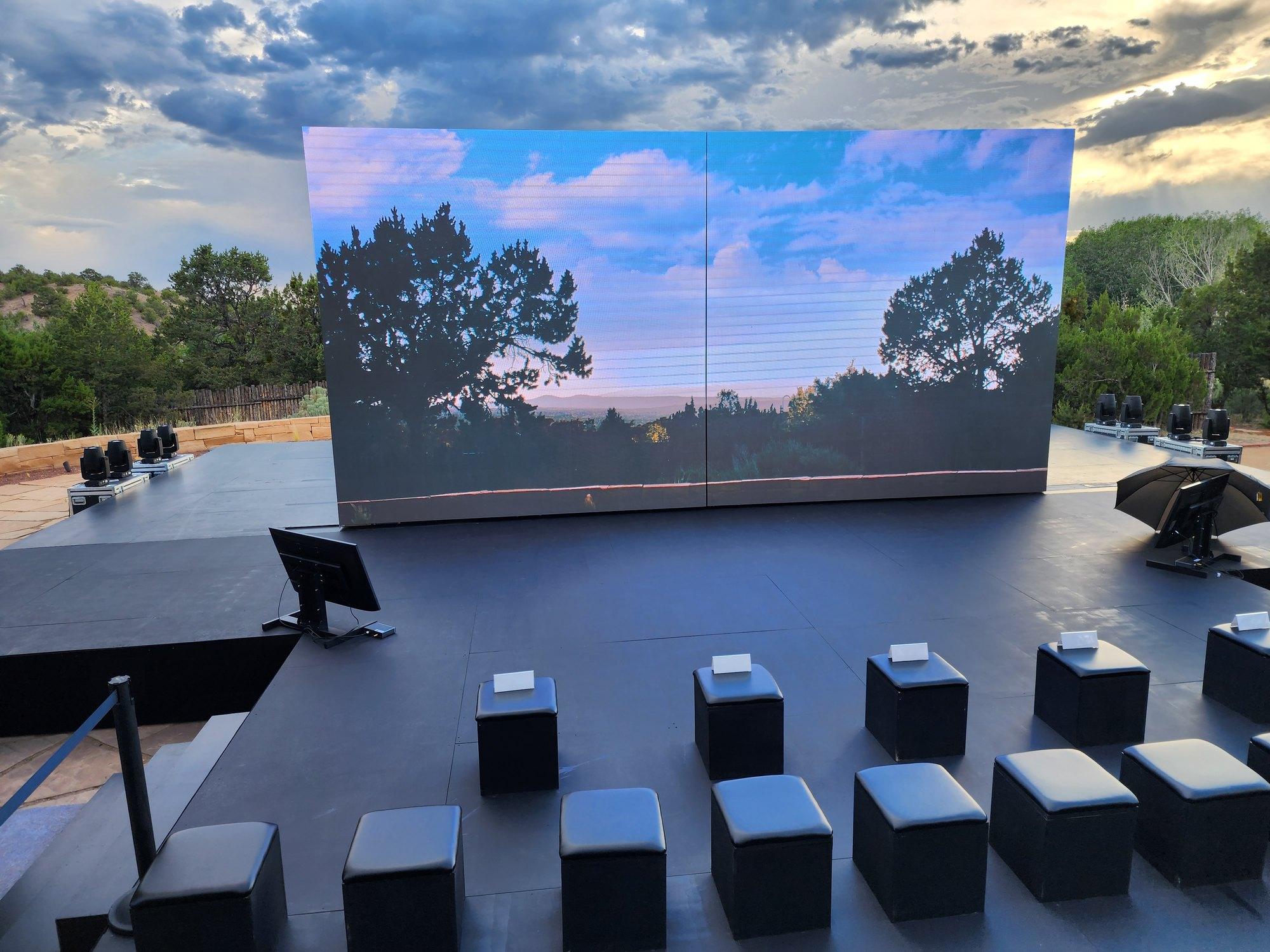 Three LED walls lit for a new-vehicle reveal in a Santa Fe event space, stage set for the premiere moment